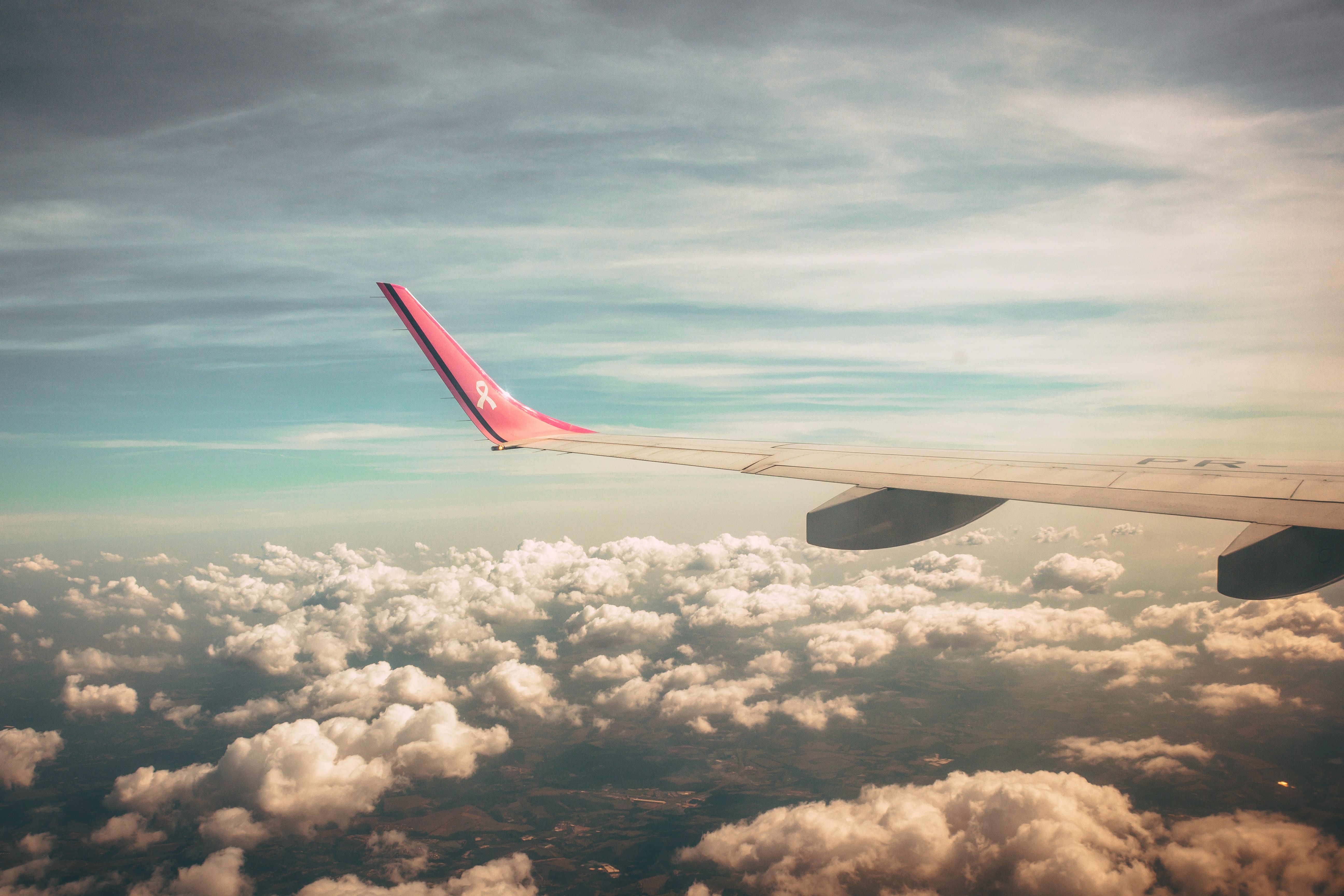 An aeroplane wing above soft clouds at sunrise